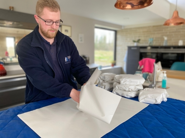 Member of Spire Removals team packing kitchen items during a house move near Salisbury, Wiltshire.