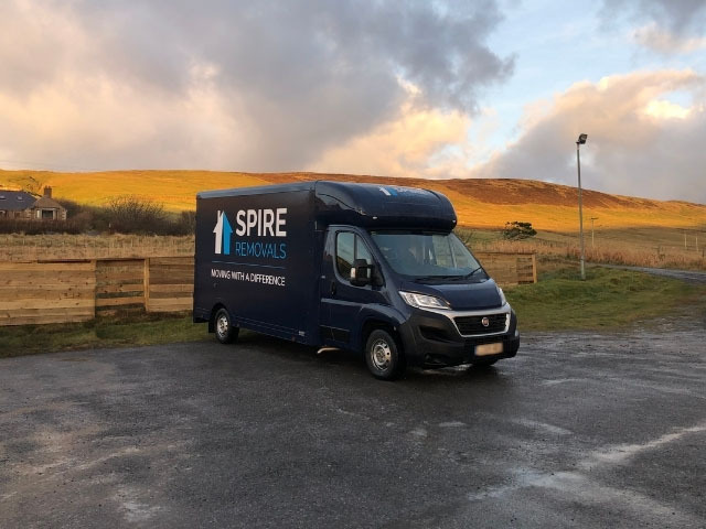 A Spire Removals van, Dorset parked by a hill during a home removal.
